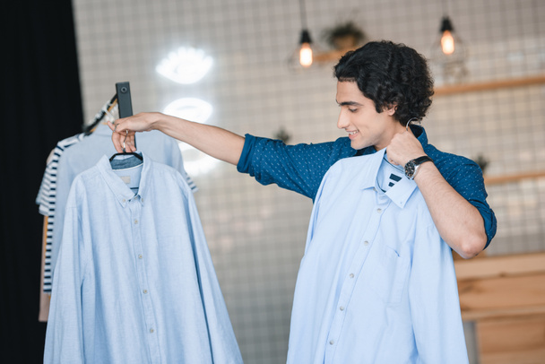 man choosing shirts in boutique   - Photo, Image