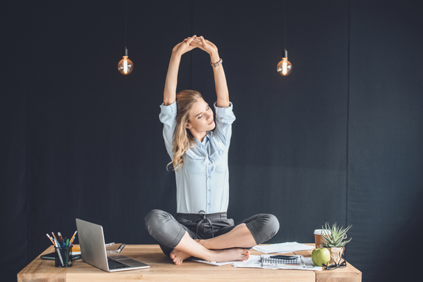 businesswoman sitting on table in office - Photo, Image