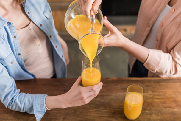 Женщины пьют апельсиновый сок
  - Фото, изображение