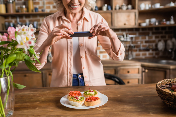 mulher placa de fotografia com alimentos na cozinha
 - Foto, Imagem