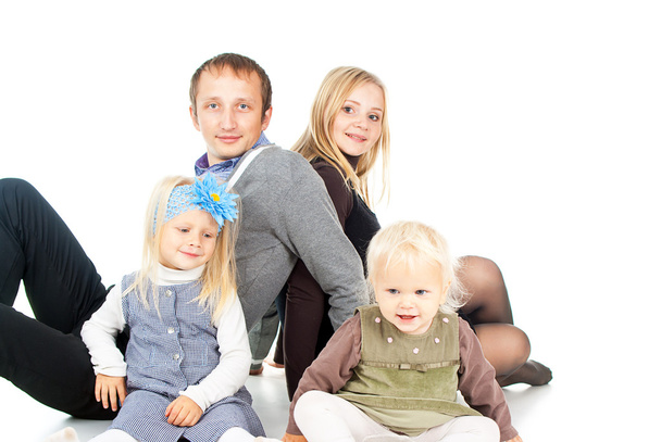 Сім'я з маленькими дітьми сидить
 - Фото, зображення