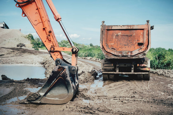 Highway construction site details with excavator bucket and dumper truck  - Fotó, kép