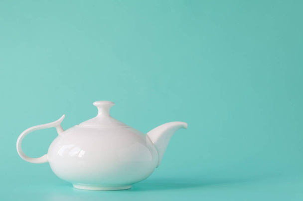 White teapot isolated on aquamarine background - Fotoğraf, Görsel