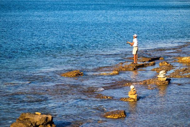 ένας ψαράς πιάνει μια ράβδο - Φωτογραφία, εικόνα
