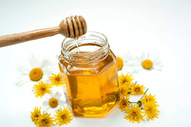 Bodegón de miel fresca y flores
 - Foto, imagen