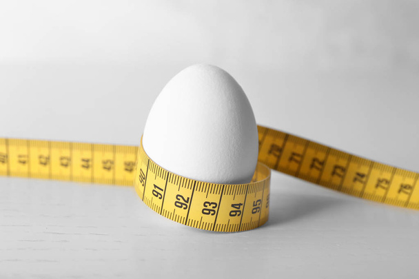 Egg with measuring tape - Fotoğraf, Görsel