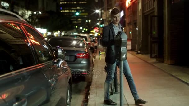 Młody człowiek płaci za dużo parkking na ulicy - Materiał filmowy, wideo