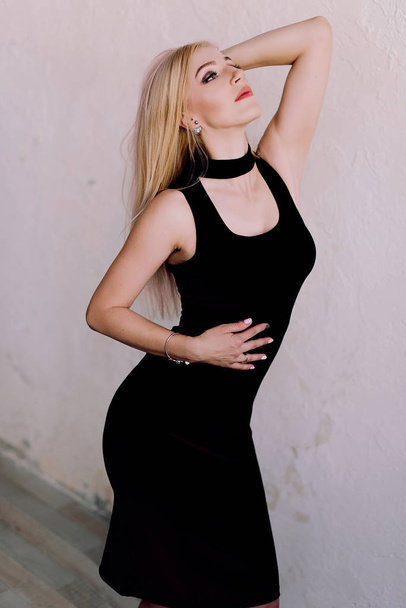 Элегантная чувственная блондинка средних лет в черном платье
 - Фото, изображение