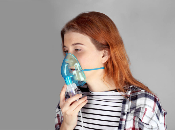 Young woman using nebulizer for asthma - Foto, afbeelding