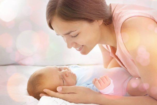 Young woman with cute sleeping baby lying on bed - Photo, Image