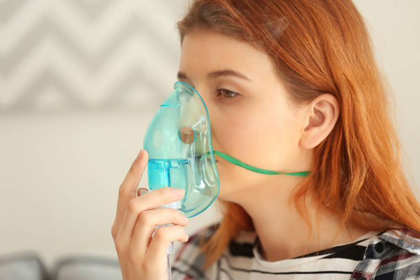 Young woman using nebulizer for asthma - Valokuva, kuva
