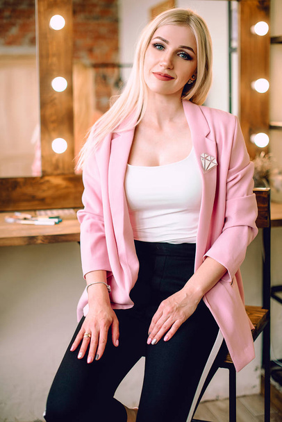 Make-up artist positive beautiful blonde woman posing near mirror in make-up room - Fotografie, Obrázek