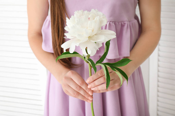 Young woman holding beautiful peony flower  - 写真・画像