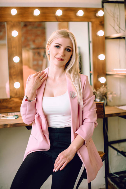 Make-up artist positive beautiful blonde woman posing near mirror in make-up room - Foto, immagini