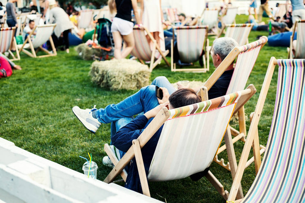 люди отдыхают на шезлонгах в летнее время
  - Фото, изображение