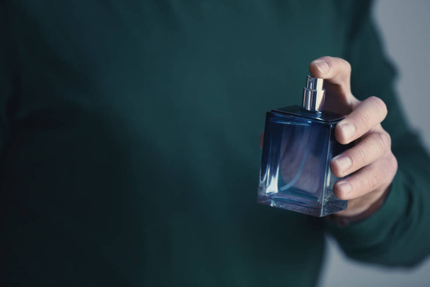 Young man with bottle of perfume - Zdjęcie, obraz