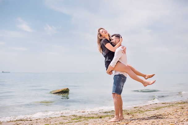 海岸で笑いながらの素敵なカップル  - 写真・画像