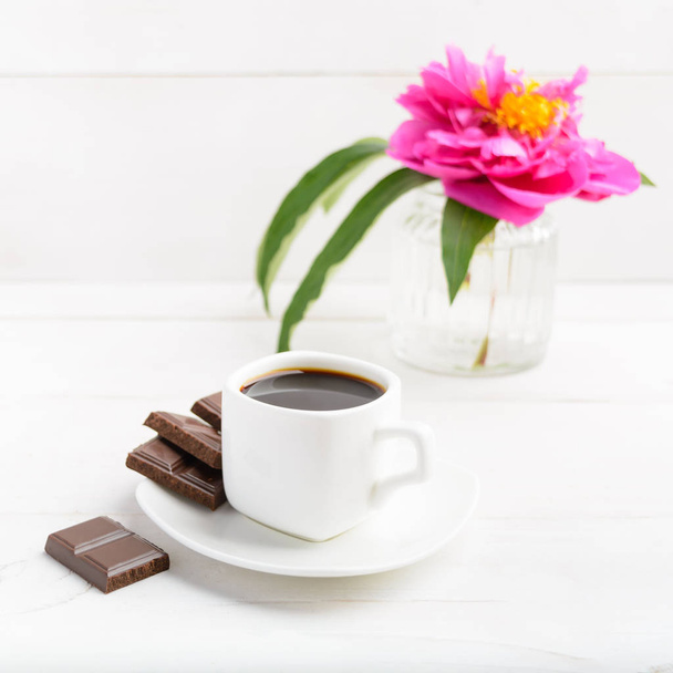 Ранкова кава і квітка над білим дерев'яним столом
 - Фото, зображення
