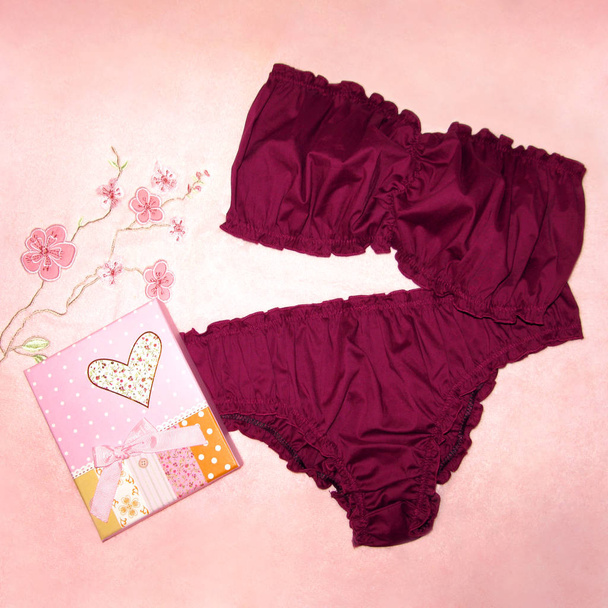 Mulher roupa interior Borgonha definir calcinha sutiã na toalha floral rosa
 - Foto, Imagem