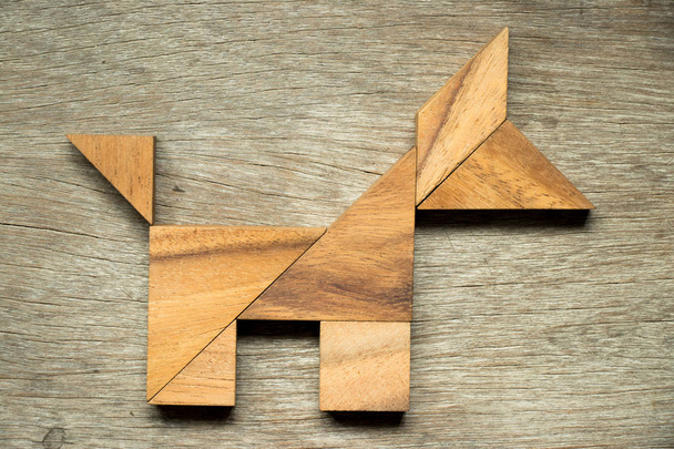 Puzzle tangram en forme de chien sur fond en bois
 - Photo, image
