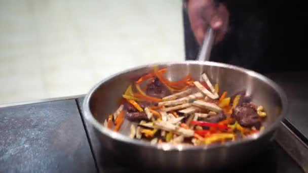 Chef putting vegetable to the pan for cooking vegetables. Chef is stirring vegetables in pan. Chef cooking vegetables in wok pan - Footage, Video