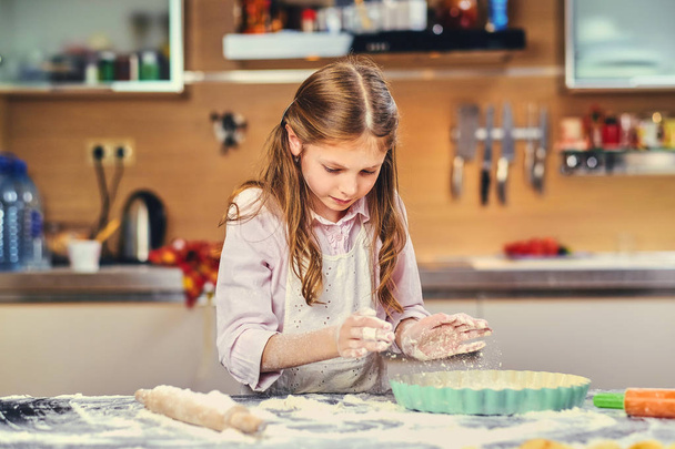 Girl cooking dough at the kitchen. - Фото, изображение