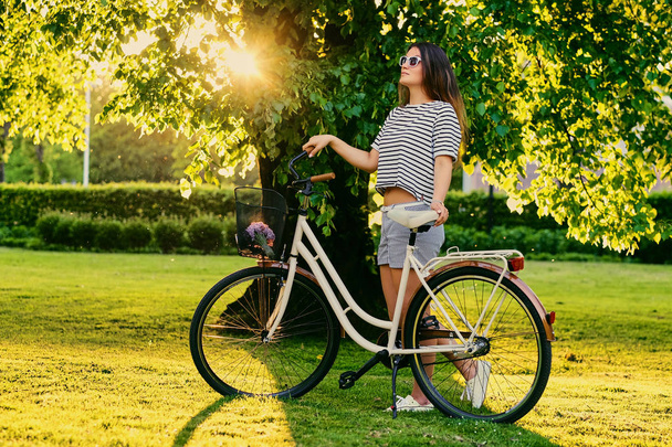 Μελαχρινή γυναίκα με ποδήλατο πόλης - Φωτογραφία, εικόνα