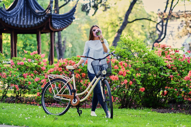 Feminino com bicicleta da cidade em um parque
 - Foto, Imagem
