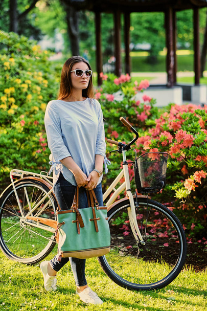 Brunetka kobiety stojącej z rowerem  - Zdjęcie, obraz