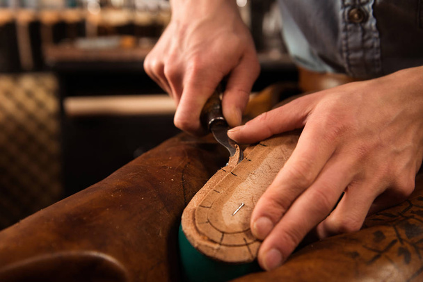 Bootmaker sitting in workshop making shoes - Photo, Image