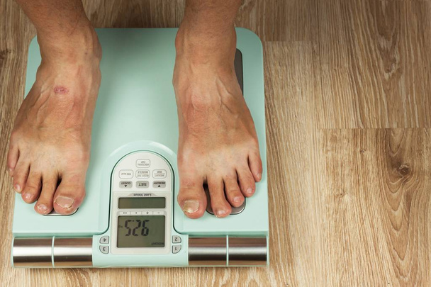The old man is standing on a modern scale. Measuring the fat content of the body. Intelligent medical weight. The concept of obesity. - Foto, Bild