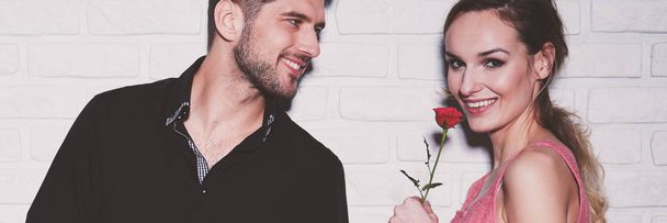 Attractive woman smelling red rose - Foto, Imagen