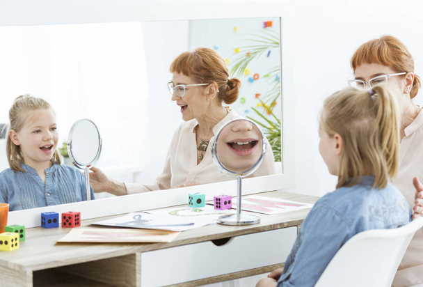 Speech therapist using mirror exercises - Фото, изображение