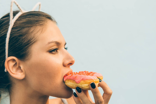 Sexy brunette lady eat sweet heart shaped donut. - Foto, Imagem