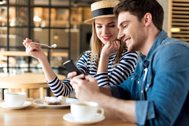 Couple utilisant un smartphone dans un café
 - Photo, image