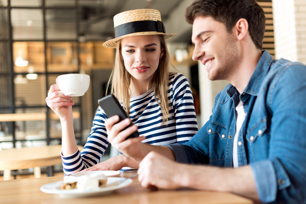 Ζευγάρι χρησιμοποιώντας smartphone στο καφέ - Φωτογραφία, εικόνα
