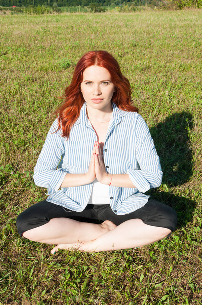 Donna attraente che fa complesso esercizio di yoga all'aperto
 - Foto, immagini