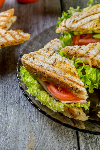 Panini sandwich with ham, tomato and lettuce. - Zdjęcie, obraz