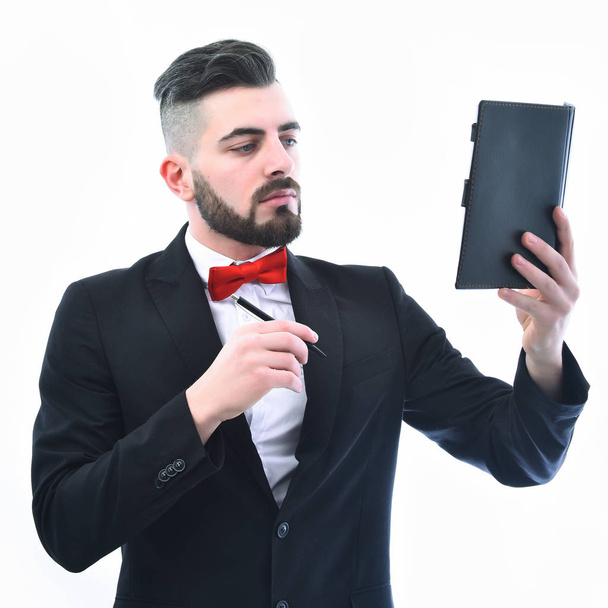 Successful businessman with beard and serious face holds black organizer - Fotografie, Obrázek