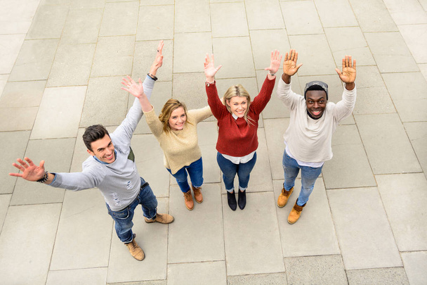 Group of different countries best friends put hands up together like one work team spirit. Top view of multiracial happy people with raised arms outdoor and sharing time. Students friendship concept. - Photo, Image