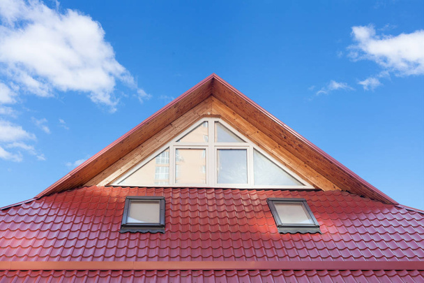 Punainen metalli kaakeloitu katto uusilla Dormers, katto ikkunat, kattoikkunat ja katto suojaa lumilauta
. - Valokuva, kuva