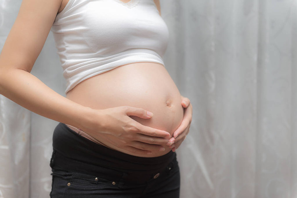 Pregnant woman touch her tummy - Fotografie, Obrázek