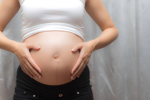 La mujer embarazada toca su barriga
 - Foto, imagen