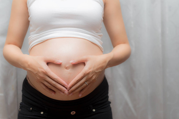 Schwangere berührt ihren Bauch - Foto, Bild