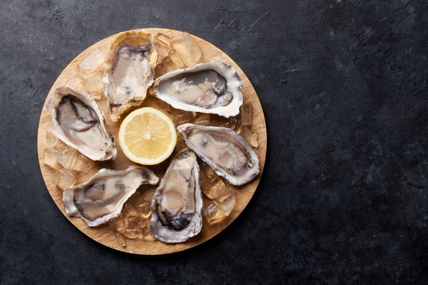 Opened Oysters and lemon over ice - Photo, Image