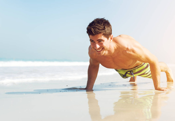 man makes push up on beach. - Valokuva, kuva