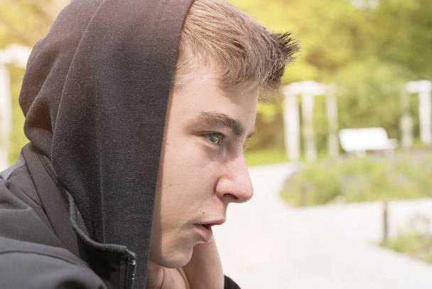 profile portrait of a young man with black hoodie - Zdjęcie, obraz