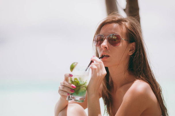 Belle fille en verres boissons cocktail sur la plage
 - Photo, image