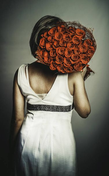standing back girl with a bouquet of roses - Foto, Bild