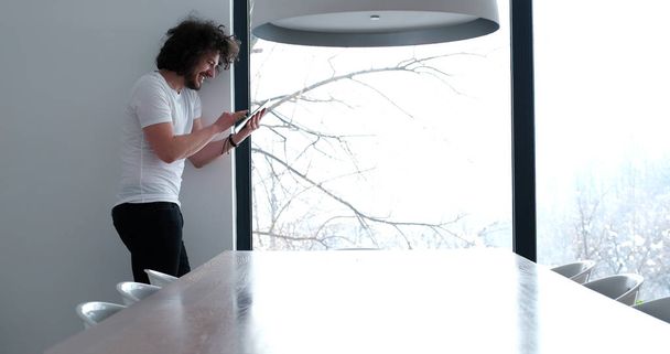 young man using a tablet at home - Фото, изображение